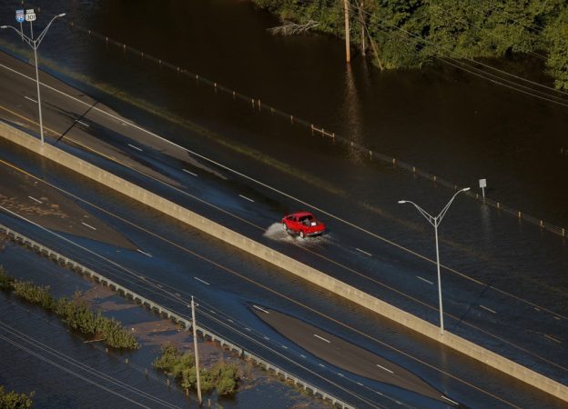 A car drives through flood waters along interstate 95 after Hurricane Matthew in Lumberton, North Carolina October 10, 2016. REUTERS/Chris Keane - RTSROGI